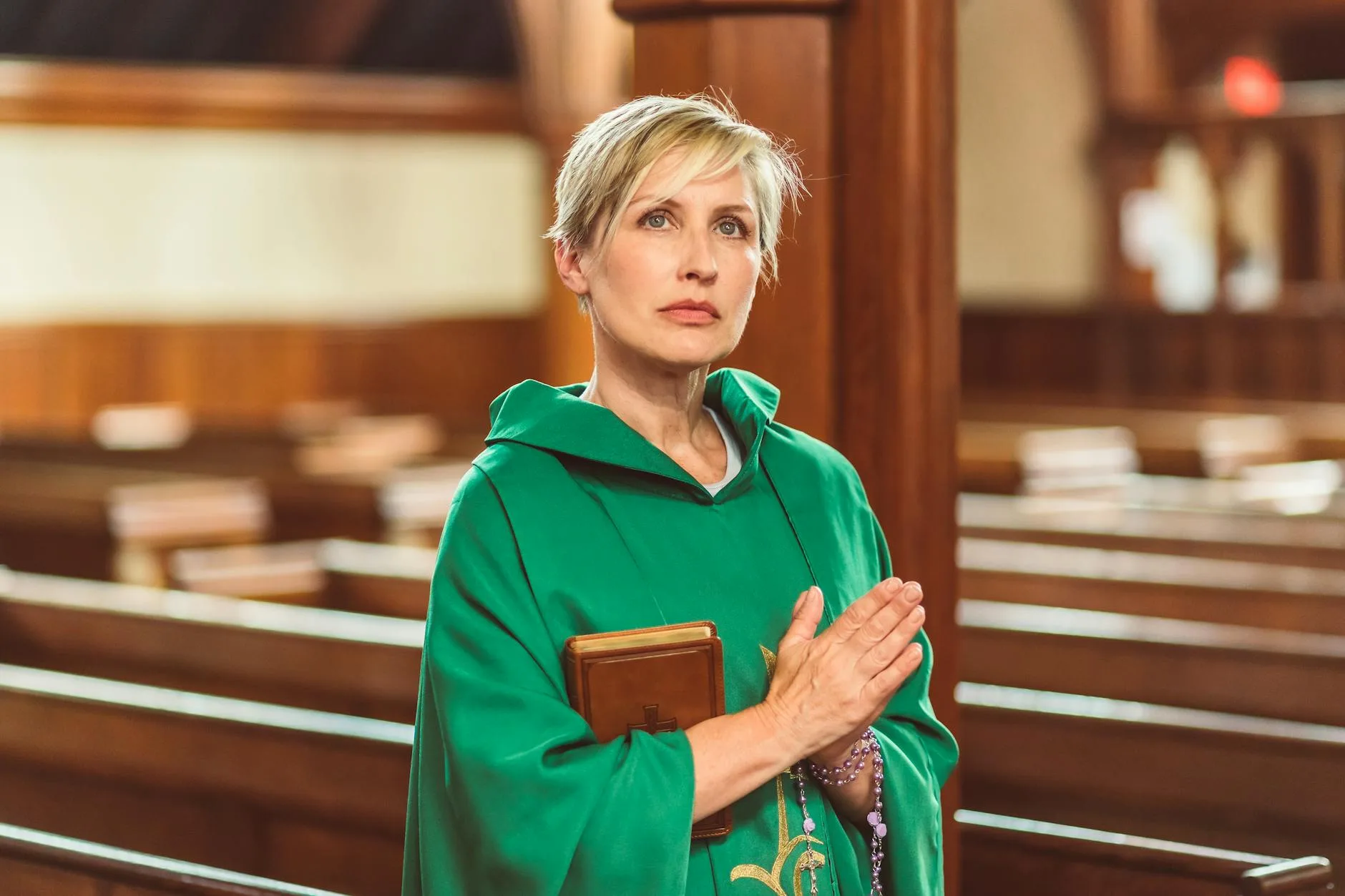 Kobieta kapłan w kościele modli się z otwartą Biblią